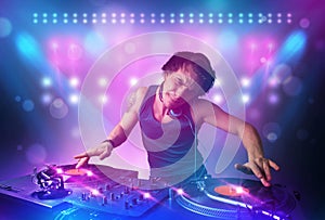 disc jockey mixing music on turntables on stage with lights and stroboscopes