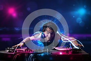 Disc jockey playing music with electro light effects and lights