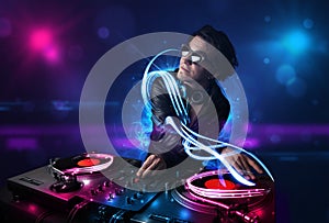 Disc jockey playing music with electro light effects and lights