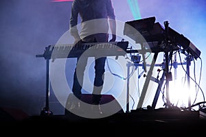 disc jokey mixing on stage over illuminated smoke background - s