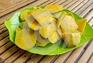 discard sweet mango slices on a plate on a bamboo table