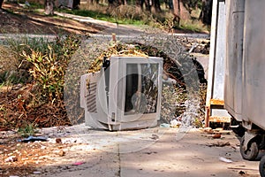 Discard TV sets on street, television near container thrown