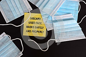 Discard used face marks safely written on yellow sticky note with face mask background