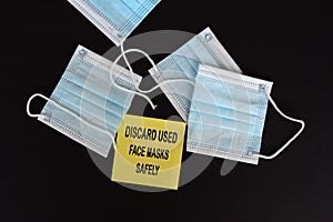 Discard used face marks safely written on yellow sticky note with face mask background