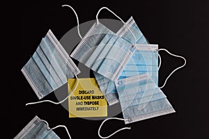 Discard used face marks safely written on yellow sticky note with face mask background