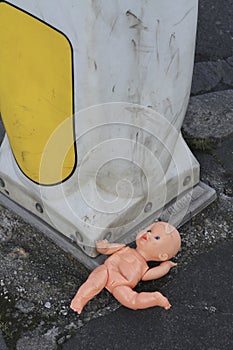 Discarded baby doll in street