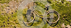 A discarded bicycle with a wicker basket to the canal, a typical example of environmental pollution in the city