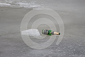 Discarded bottle of champagne on ice