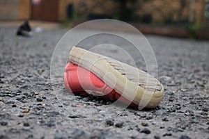 Discarded children\'s pink shoe upside down in a public space