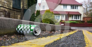 Discarded drinks can lying at the edge of an urban street