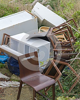 A discarded fridge and chairs