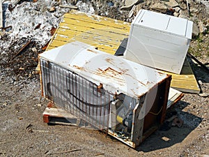 Discarded fridge and dryer in a junk pile