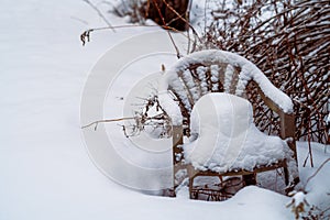 discarded garden plastic chair abandoned in the snowdrift, winter scene