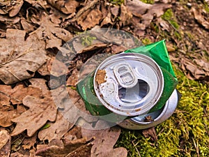 Discarded green aluminium beer or soda can in a forest