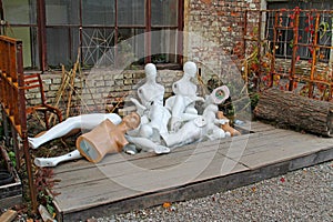 Discarded nude mannequins in junkyard.