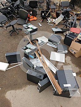 discarded obsolete system units from computers with old office chairs in trash