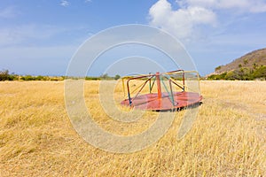 Discarded playground apparatus in an overgrown field on bequia