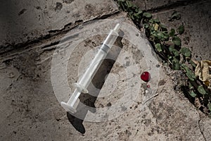 Discarded syringe on concrete outdoors - close up drug concept i