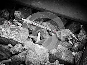 Discarded syringe lying amongst stones