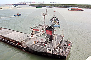 Discharging the vessel in the port of Saigon, Vietnam, the Mekong River. Views of berths, river banks and ships,tugs. photo