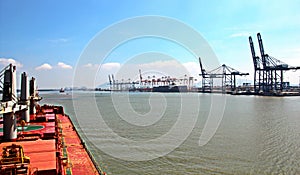 Discharging the vessel in the port of Saigon, Vietnam, the Mekong River. Views of berths, river banks and ships,tugs.