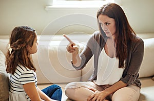 Discipline starts here. a young girl being reprimanded by her mother at home.