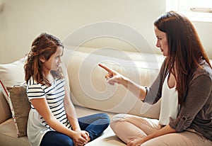 Discipline starts at home. a young girl being reprimanded by her mother at home.
