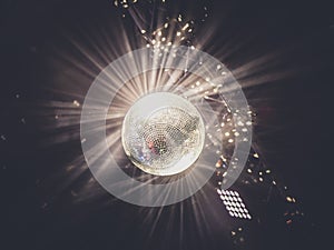 Disco ball with bright rays, night party background