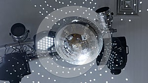 Disco ball rotates under the ceiling in a nightclub, glitters and reflects light