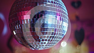 Disco ball rotating nightclub radiating glitter rays closeup. Dance celebration