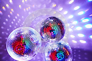 Disco balls with mirror reflections and lights at a night party in a bar or club