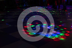 Disco in club. Dance floor in colored spots. Light music in club