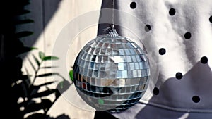 Disco Mirror Ball Spinning. Female hand spin disco ball at home. Sunlight. Daytime