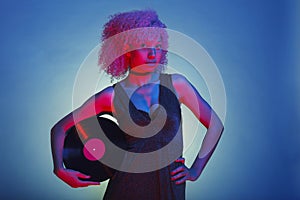 disco woman with afro hair holding a vintage vinyl on neon