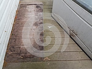 Discolored or worn or weathered wood deck boards with algae and storage box