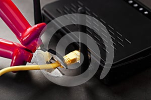 Disconnecting the Internet connection, cutting off the yellow Ethernet cable with wire cutters with a red handle on the Wi-Fi