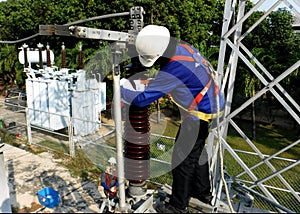 Disconnecting switch insulator cleaning by a worker at Take-off tower in substation photo