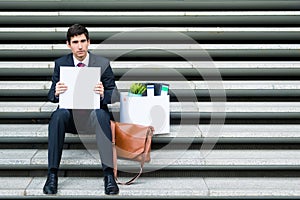 Disconsolate businessman holding a blank sign