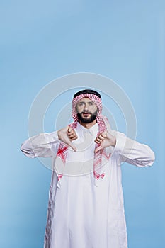 Discontent arab posing with thumbs down