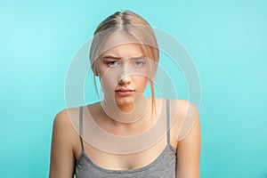 Discontent female, being upset, isolated over blue studio background.