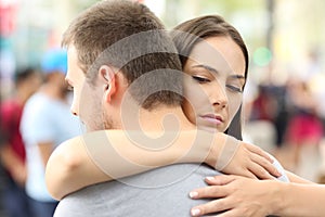 Discontent girlfriend hugging her partner
