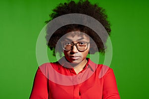 Discontent serious young African-American girl in glasses and red shirt