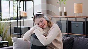 Discontent Woman In Headphones Listening Music At Home