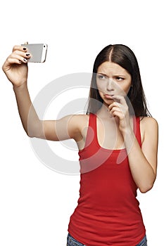 Discontent woman taking pictures of herself through cellphone