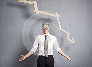 Discontented businessman in front of graph with negative trend.