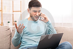 Discontented Man Calling To Customer Support Sitting With Laptop Indoor