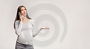 Discontented Pregnant Lady Talking On Cellphone Complaining, Gray Background, Panorama