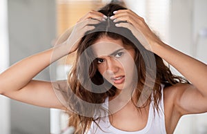 Discontented Woman Suffering From Dandruff Looking At Hair Flakes Indoor