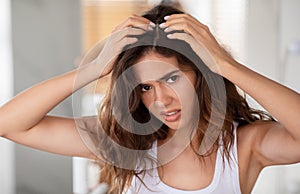 Discontented Woman Suffering From Dandruff Looking At Hair Flakes Indoor photo