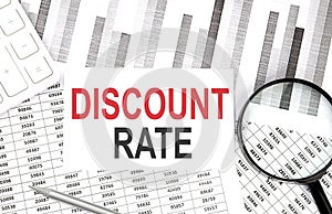 DISCOUNT RATE text on paper with calculator,magnifier ,pen on graph background